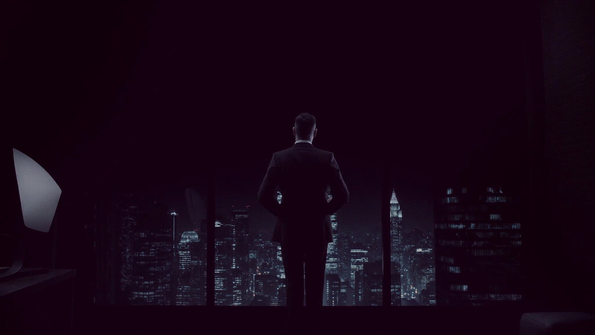 A founder standing alone at his office window above the lights of Miami at night